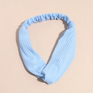 Détail d'un bandeau de yoga en tricot bleu clair avec nœud torsadé et texture côtelée