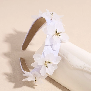 Serre-tête large élégant avec fleurs 3D blanches et centre doré sur présentoir de vase