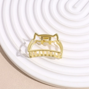 Detail of golden metal cat-ear hair claw clip showing polished alloy surface and teeth
