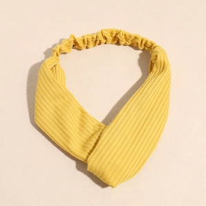 Détail du bandeau en maille côtelée jaune vif avec un nœud torsadé et une texture douce