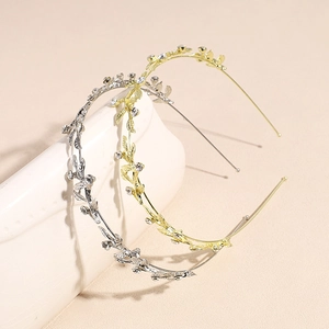 Elegant gold and silver leaf vine headbands with white rhinestones on beige background