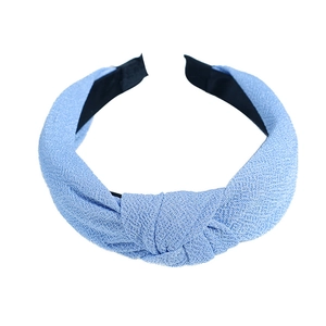Light blue knitted wide headband with knot detail for women on white background