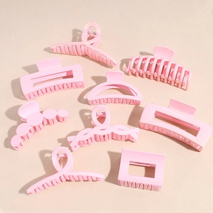 Set of 8 matte pink hair claw clips in various shapes on a beige background