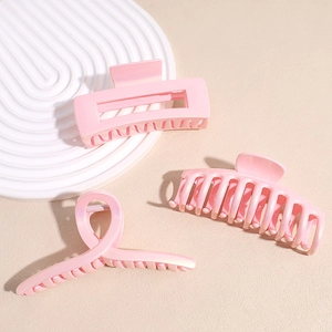 Three-piece set of glossy pink hair claw clips in rectangular and twisted styles