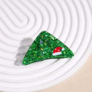 Détail de la pince à cheveux triangle verte avec paillettes étoiles et bonnet de Noël