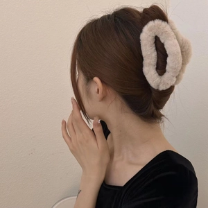 Fluffy cream plush hair claw clip shown on model for elegant back of head styling