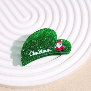 Détail de pince à cheveux de Noël verte pailletée avec motif Père Noël et lettrage