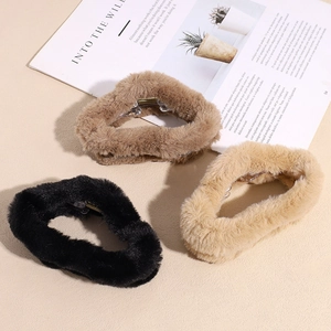 Plush faux fur cloud hair claws in black, brown, and khaki on a stylish magazine