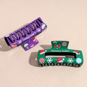 Large Christmas hair claws featuring purple snowflake and green Santa Baby designs