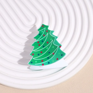 Détail de la pince à cheveux sapin de Noël avec points colorés sur plateau blanc