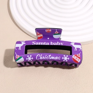 Detail of purple Christmas hair claw clip with reindeer patterns and Santa baby text