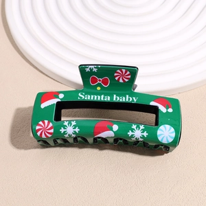 Detail of green Christmas hair claw clip with Santa Baby print and festive patterns