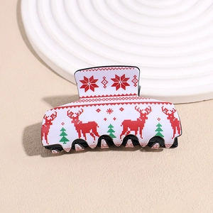 Close-up of Christmas acrylic hair claw clip with reindeer and tree pixel pattern