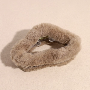 Detail view of plush faux fur hair claw clip in beige with golden metal spring mechanism