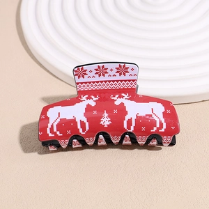 Detail of red acrylic hair claw clip with pixelated Christmas reindeer and tree prints