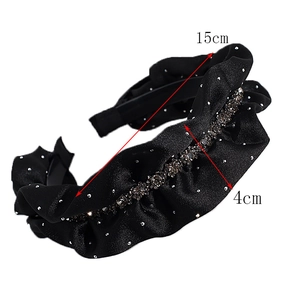 Detail view of black velvet headband with ruffles, rhinestones, and 4cm width dimensions