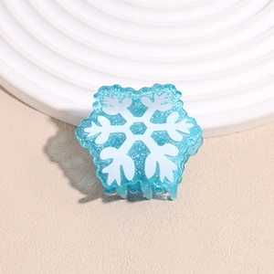 Close-up of blue translucent hair claw clip with silver glitter and white snowflake patterns