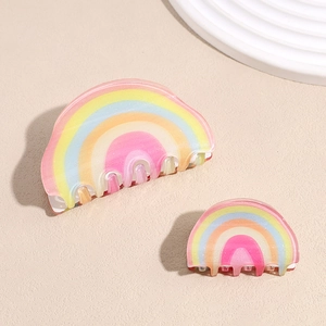 Rainbow gradient acrylic hair claw clip set with glitter finish on textured surface