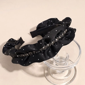 Detailed macro view of black velvet headband with white polka dots and grey rhinestones