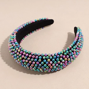 Detailed view of wide headband with iridescent faux pearls and black velvet lining