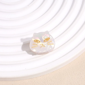 Detalle de pinza para el pelo de gato tornasolada con rasgos dorados en plato blanco