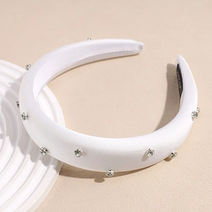 Détail d'un serre-tête en satin blanc avec des strass en cristal brillants et doublure interne