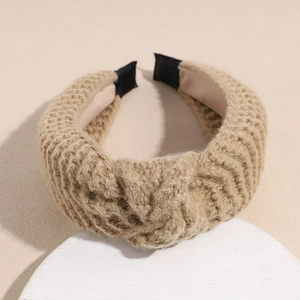Close-up of khaki knitted headband showing thick textured yarn and satin lining detail