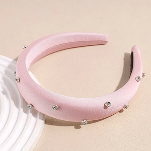Détail du serre-tête rose rembourré en satin orné de strass brillants et élégants