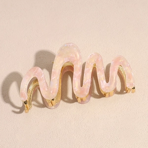 Detailed view of pink marble wave hair claw clip with a polished gold metal inner frame