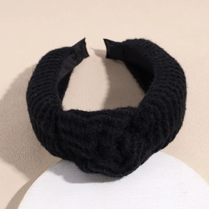 Detailed macro view of the thick black knitted headband with textured plush fabric