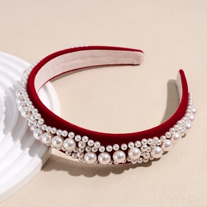 Detail of red velvet baroque headband featuring rows of elegant white pearls