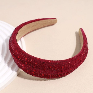 Detailed side view of a wide burgundy padded headband with sparkling rhinestones decoration