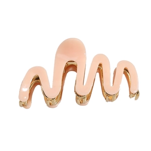Elegant peach acetate shark hair claw with wavy design and golden metal spring clip