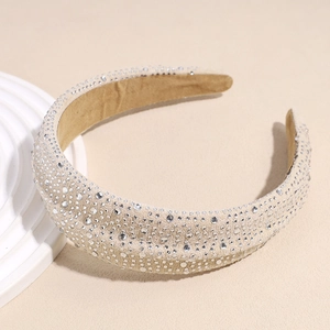 Close-up of beige wide headband with intricate silver rhinestones on suede fabric