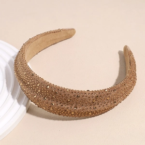 Close-up of padded velvet headband with gold rhinestones and retro textured finish