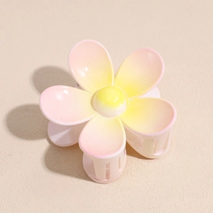Vue détaillée d'une pince à cheveux fleur rose avec dégradé jaune et dents fonctionnelles