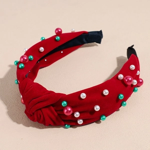 Détail d'un serre-tête de Noël en velours rouge avec perles blanches et perles colorées