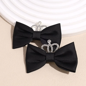 Close-up of velvet black bow hair clips featuring silver crown and sparkling rhinestones