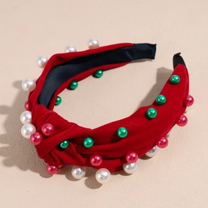 Détail du serre-tête de Noël en velours rouge avec nœud torsadé et perles colorées