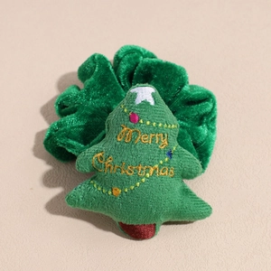 Detail of green velvet Christmas scrunchie with embroidered Merry Christmas tree decor