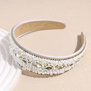 Detailed close-up of handmade white seed beads and marquise rhinestones on a wide headband