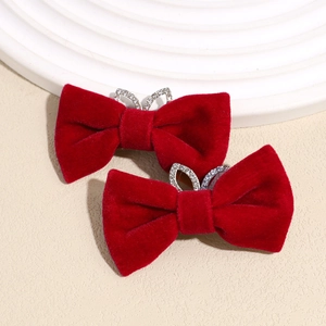 Pair of red velvet bow hair clips with crystal rabbit ear details on a white textured tray