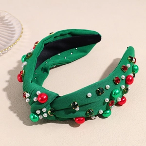 Detail of green knitted Christmas headband with red green rhinestones and faux pearls