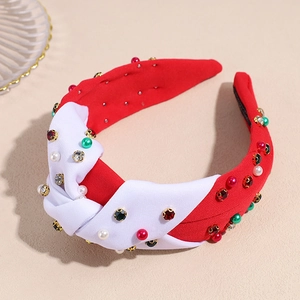 Macro detail of red and white knotted headband with pearls and sparkling rhinestones
