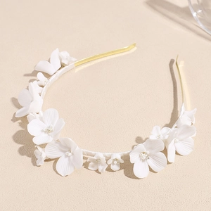 Elegant bridal headband featuring handmade white ceramic flowers and a slim gold metal frame