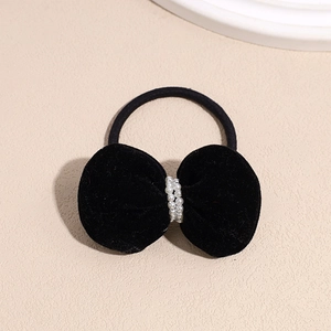 Detailed view of a black velvet bow hair tie with rows of elegant white faux pearls