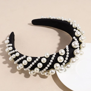 Close-up of black sponge headband with white pearls in elegant baroque style and retro texture