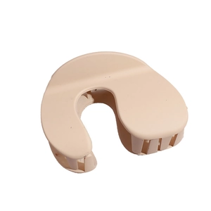 Minimalist beige matte shark hair claw clip with horseshoe U-shape design on white background