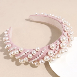 Close-up of pink fabric headband featuring high-quality pearls and elegant baroque details