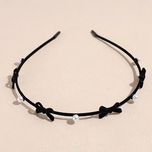 Detail of black flocked headband with elegant white pearls and small velvet bows